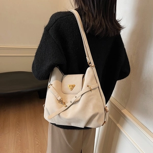 Minimalist beige matte leather tote bag with iconic golden triangle plaque and slim strap