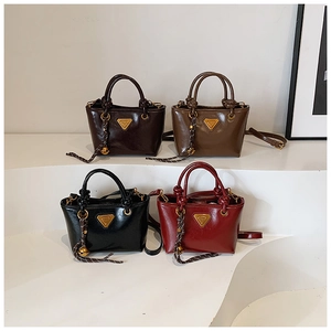 Détail de quatre mini-sacs vintage en cuir brillant avec logo triangle et nœud décoratif