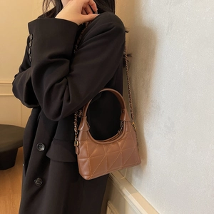 Sac à main rétro en cuir matelassé marron avec bandoulière chaîne porté par un mannequin