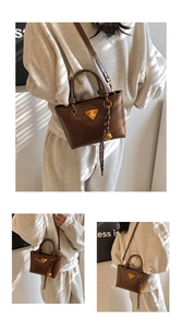 Détail du sac cabas vintage en cuir marron avec poignée en corde et plaque logo en métal