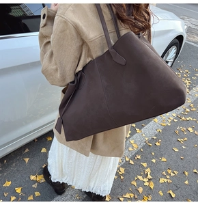 Brown suede tote bag with large capacity shown on model in autumn street setting