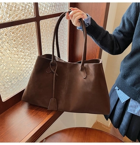 Close-up of matte dark brown tote bag with high-quality leather texture and fine stitching