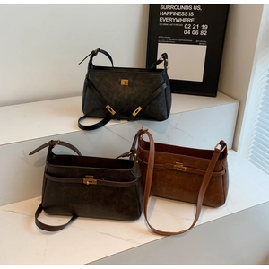 Dettaglio borse vintage in pelle opaca nera e marrone con finiture metalliche oro