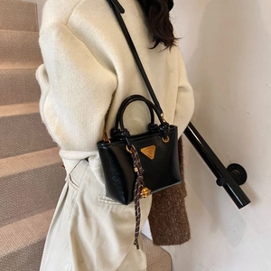Sac seau rétro en cuir noir avec logo triangulaire doré et bandoulière pour femme