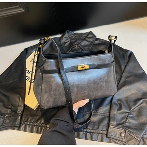 Dettaglio borsa vintage in pelle grigia con chiusura a scatto dorata e cinturini neri
