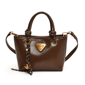 Sac cabas vintage en cuir marron avec emblème doré et bandoulière décorative