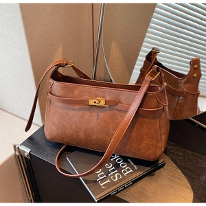 Dettaglio borsa vintage marrone con chiusura girevole dorata e texture in pelle