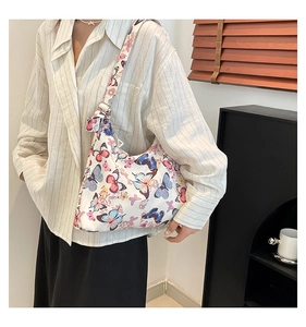 Dettaglio borsa tote in tela con farfalle colorate e tracolla ampia regolabile in metallo