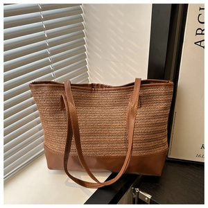 Vue détaillée du grand sac cabas en paille marron avec base en cuir et anses robustes