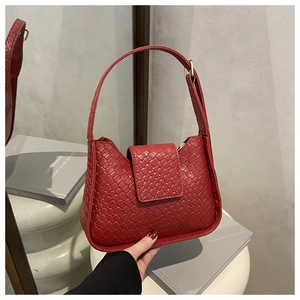 Détail du sac hobo en cuir tressé rouge avec boucle dorée et fermeture à rabat