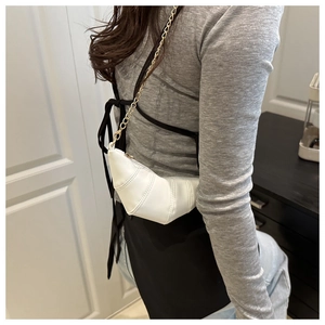 Détail du sac croissant blanc avec bandoulière chaîne dorée et texture en similicuir plissé