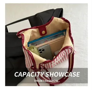 Spacious interior of red striped tote bag showing storage for tablet, umbrella and phone