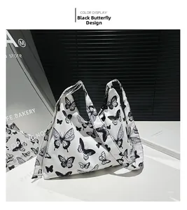 Dettaglio della borsa hobo in tela con stampa a farfalla nera su fondo bianco