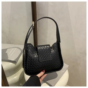 Gros plan d'un sac à bandoulière tressé noir avec forme de lune et fermeture éclair dorée