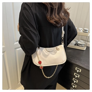 Detail of white lychee pattern bag with gold chain and red strawberry charms