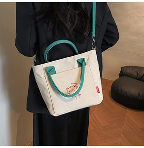 Rückansicht eines Models mit beiger Canvas-Umhängetasche, grünen Trägern und Bärenmuster