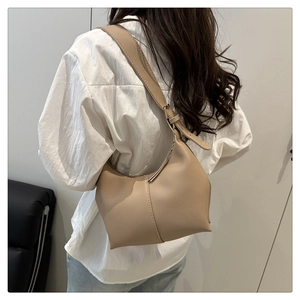 Detail of minimalist cream leather crescent shoulder bag with wide adjustable strap