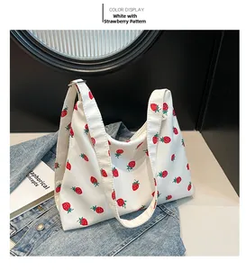 Vista dettagliata della borsa di tela bianca con stampa di fragole su denim