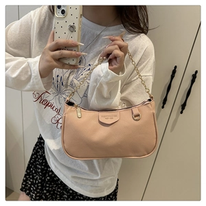 Rosa Achseltasche aus Leder mit Litschistruktur und goldener Kette in der Hand