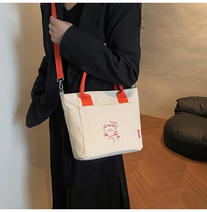 Detail der Canvas-Einkaufstasche mit orangen Trägern, Bären-Motiv und Vordertasche