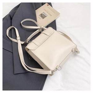 Détail du mini sac à dos en cuir PU blanc crème avec boucles argentées et poignée