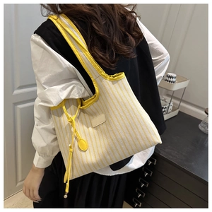 Vue détaillée du sac cabas rayé avec texture en tissu jaune et cordons décoratifs