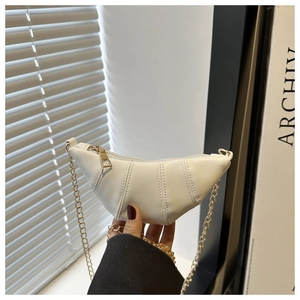 Vue détaillée du sac croissant blanc avec surpiqûres verticales et chaîne dorée
