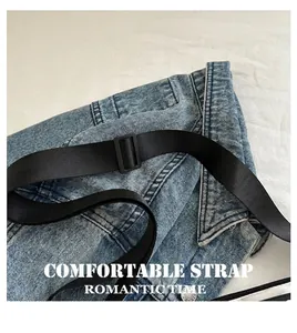 Détail de la bandoulière réglable en nylon noir avec boucle sur sac en denim bleu