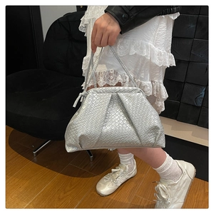 Detail of silver woven cloud handbag showing metallic texture and braided design