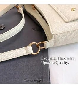 Close-up of golden hardware buckle and lychee textured leather on crossbody bag