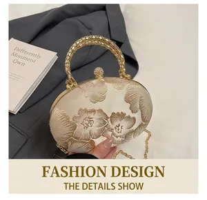 Detail of floral embroidery, woven metal handle and rhinestone clasp on a satin clutch