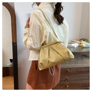 Golden crocodile texture pleated cloud bag shown on model with shoulder strap style