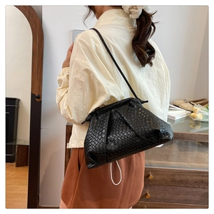 Detail of black woven cloud bag showing intricate PU leather texture and shoulder strap
