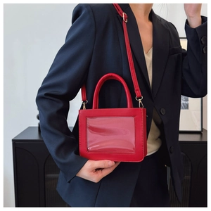 Détail du petit sac carré rouge avec fenêtre PVC et bandoulière réglable