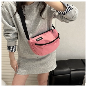 Sac bandoulière demi-lune rose porté, montrant la texture nylon et le logo mode