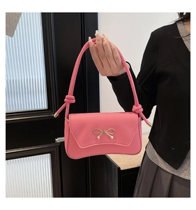Dettaglio della borsa sottobraccio in PU rosa con fibbia a fiocco in metallo dorato