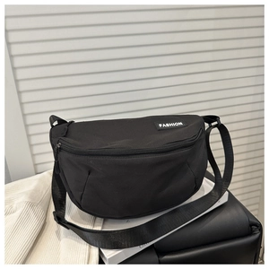 Détail d'un sac bandoulière croissant en nylon noir avec sangle réglable et étiquette