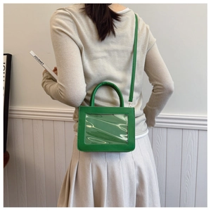 Détail du sac à main vert vif avec fenêtre PVC transparente et bandoulière amovible