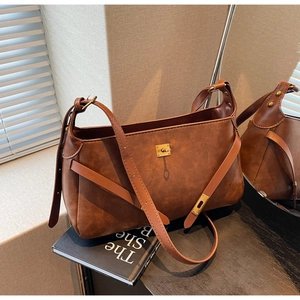 Dettaglio di una borsa marrone vintage con fibbia in metallo dorato e trama opaca