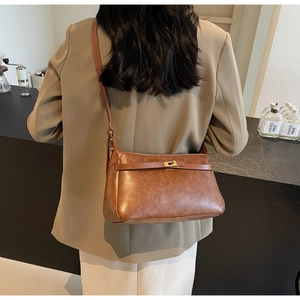 Dettaglio della borsa a tracolla marrone vintage in pelle opaca con fibbia dorata