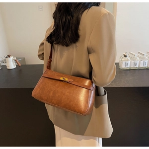 Dettaglio della borsa a tracolla vintage in pelle marrone con chiusura a scatto oro