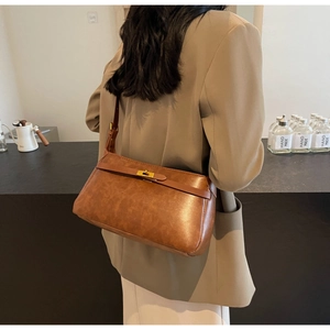 Dettaglio della borsa vintage in pelle marrone con fibbia in metallo dorato e chiusura a patta