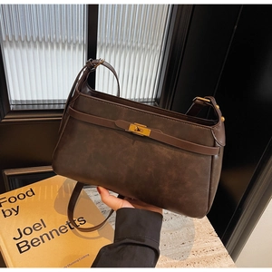 Dettaglio di borsa a spalla vintage in pelle marrone scuro con chiusura dorata