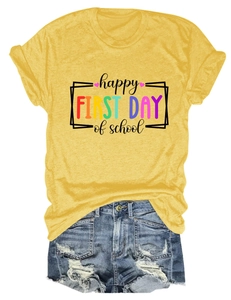 Dettaglio della maglietta gialla Happy First Day of School e pantaloncini in denim