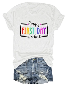 Dettaglio della scritta happy first day of school su t-shirt bianca e shorts in denim