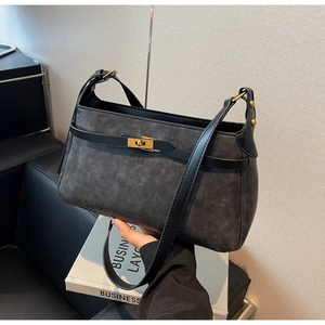 Dettaglio della borsa a tracolla vintage con classica chiusura girevole in metallo dorato