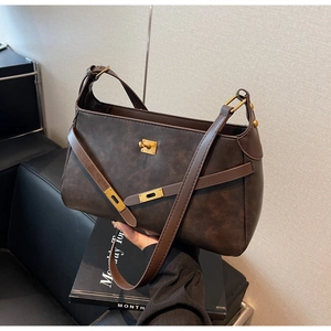 Dettaglio della borsa vintage in pelle marrone con classica chiusura a girello in metallo
