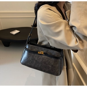 Dettaglio della borsa a spalla in pelle grigia vintage con chiusura dorata e grana fine