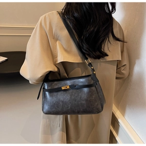 Dettaglio della borsa a tracolla vintage in pelle grigia cerata con fibbia dorata