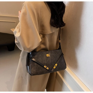 Dettaglio borsa a tracolla vintage in pelle opaca con chiusura hardware dorata lucida